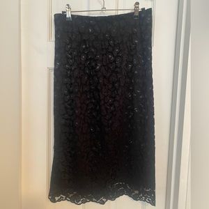 Lace overlay pencil skirt with subtle sheen. Classic elegance.